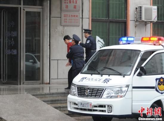 2012年4月25日,中国足坛第二批反腐案进入第二庭审日,原中国国家体育总局足球运动管理中心主任、中国足协副主席南勇受贿一案,在辽宁省铁岭市中级人民法院开庭审理。图为南勇在警察的押送下步入审判庭。中新社发 司晓帅 摄