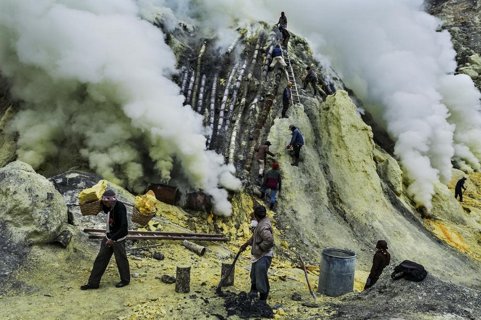 祭祀仪式过后,硫磺矿工们继续在火山口工作.